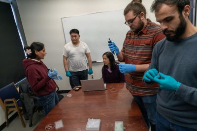 Researchers gathered around a table, running tests