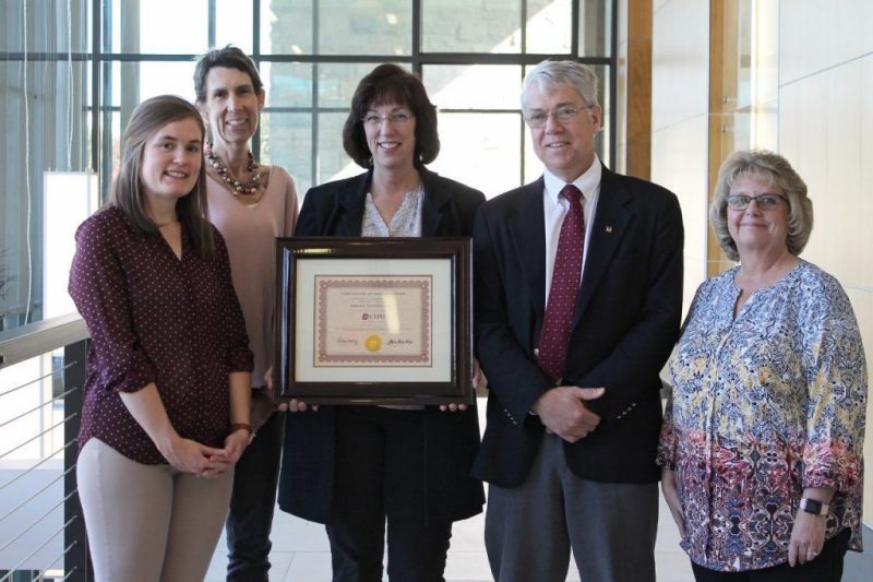 Photo of program and college administration with CEPH re-accreditation certificate