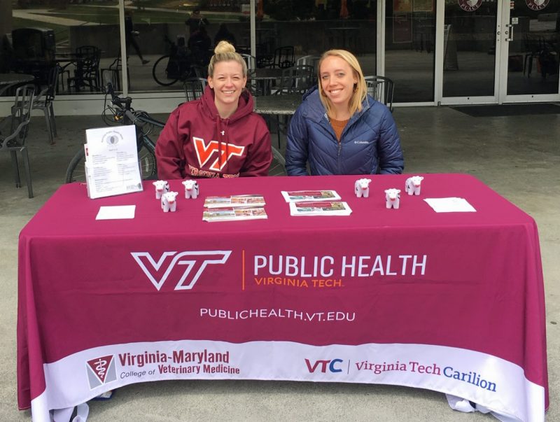 MPH students Harper Lovegrove and Shelby Borowski sitting at their table outdoors on campus