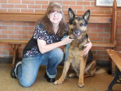 Sally Suttenfield (at left) posing with a German Shepard patient