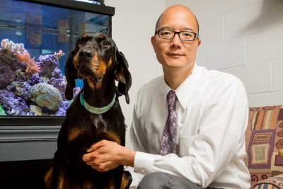 Timothy Fan (at right) with his dog Ember (at left), a doberman